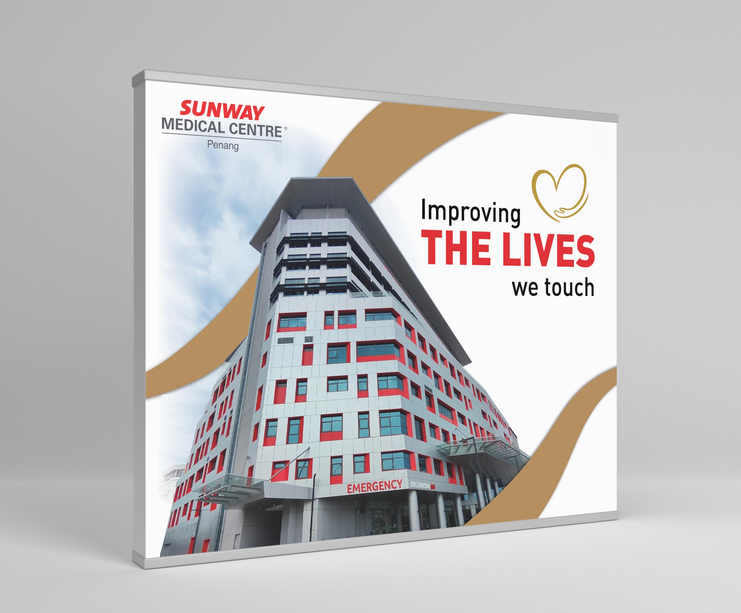 Signage mockup for Sunway Medical Centre Penang with text 'improving the lives we touch'