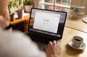 A person browsing internet with a cup of coffee